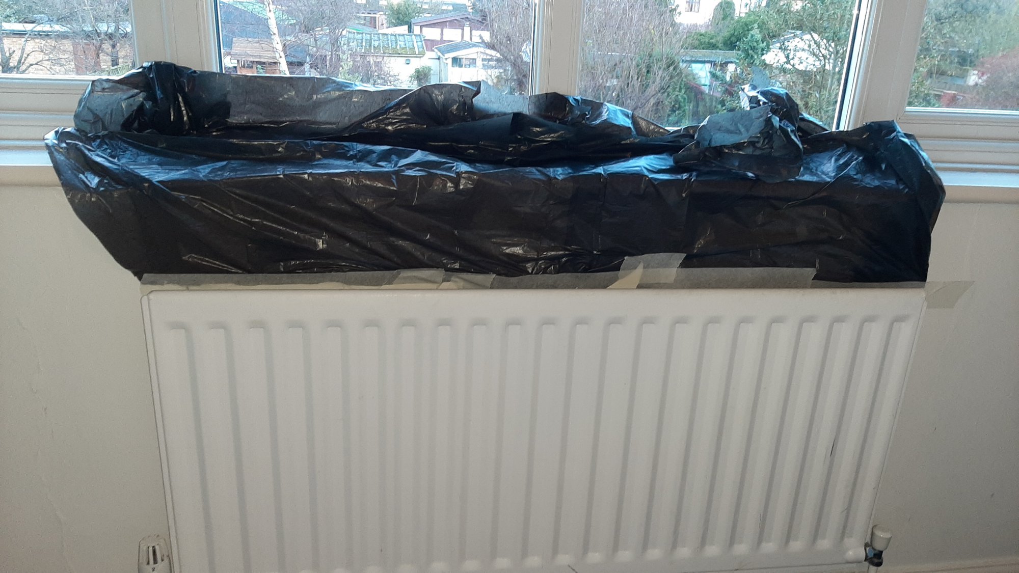 bin bag fixed to wall to stop glue getting everywhere