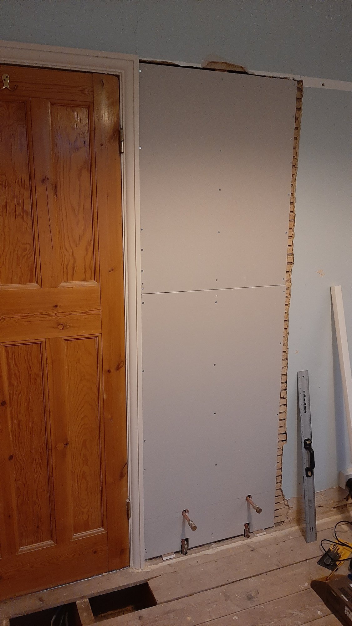 the wall boarded with fresh plasterboard, ready to be skimmed with plaster